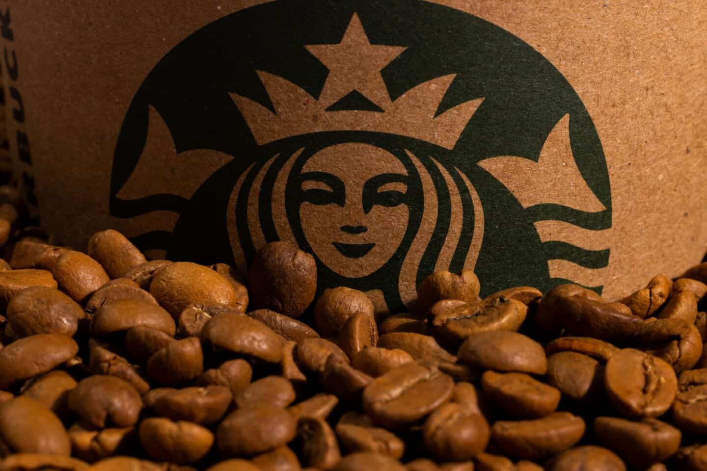 a starbucks cup surrounded by roasted coffee beans