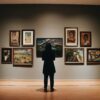 Pessoa observando pinturas em uma galeria de arte. Imagem ilustra artigo do Barrazine sobre galerias e museus do Rio de janeiro (A Barra da Tijuca tem boas galerias e alguns dos melhores museus do Rio de Janeiro).