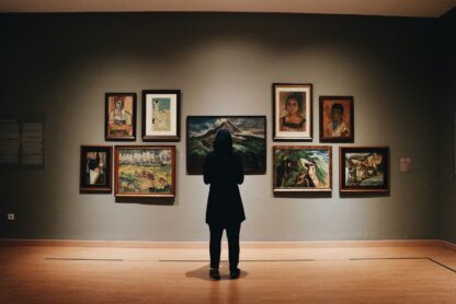 Pessoa observando pinturas em uma galeria de arte. Imagem ilustra artigo do Barrazine sobre galerias e museus do Rio de janeiro (A Barra da Tijuca tem boas galerias e alguns dos melhores museus do Rio de Janeiro).