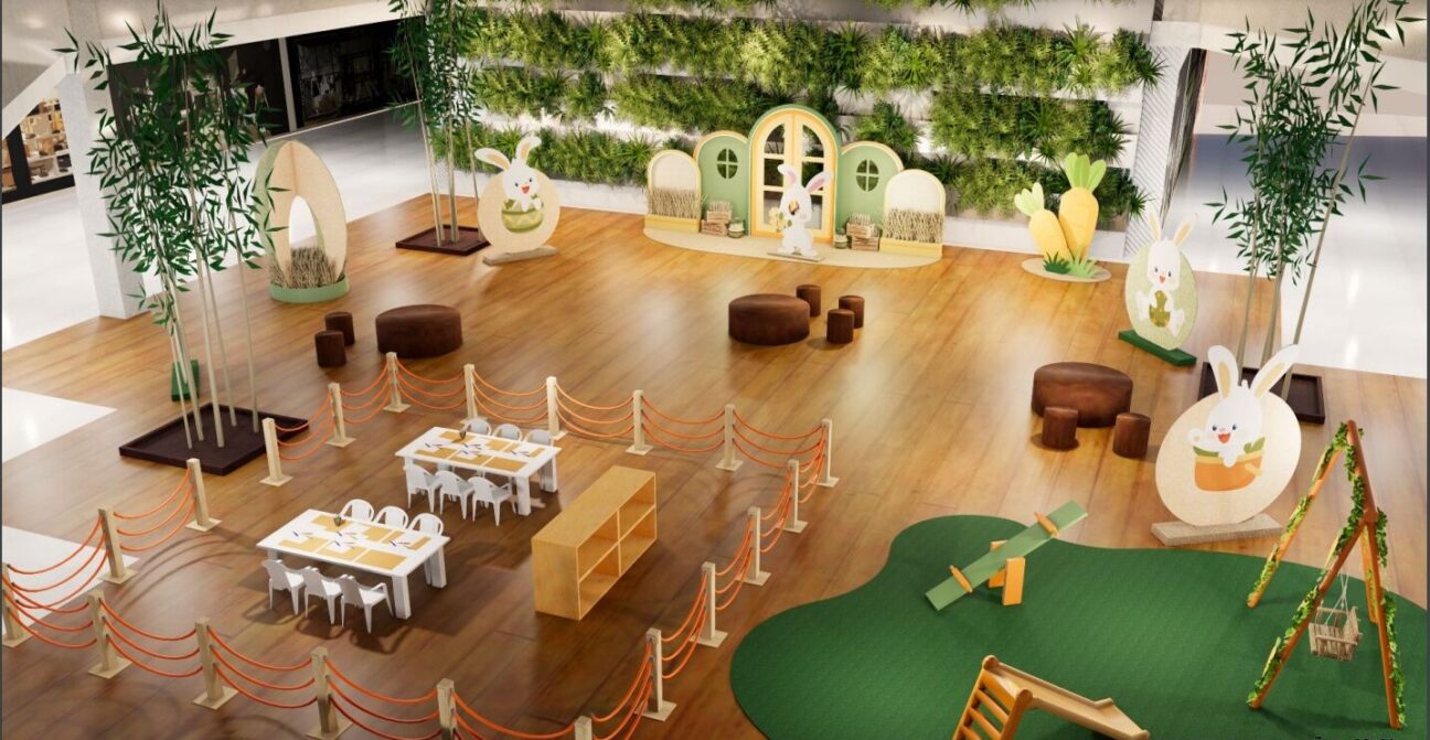 Área de recreação infantil no Rio Design Barra coberta com assentos, seção de minigolfe e decorações temáticas de Páscoa.